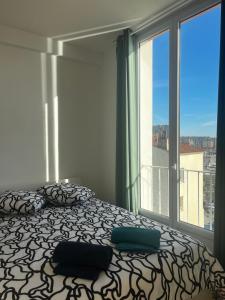 a bedroom with a bed and a large window at Le marin in Toulon