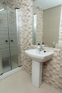 y baño con lavabo y ducha. en Puerta Real Luxury Apartments Granada, en Granada