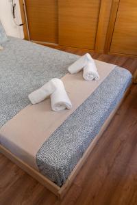 Una cama con dos toallas enrolladas encima. en Puerta Real Luxury Apartments Granada, en Granada