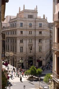 un gran edificio con gente caminando delante de él en Puerta Real Luxury Apartments Granada, en Granada