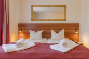 a bedroom with a large bed with towels on it at Hotel Mira Mare in Heiligenhafen