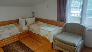 a room with a bed and a chair and a window at Vitosha Guest House in Devin