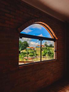 a window in a brick wall looking out at a yard at Pousada Di Venezia - Hotel Fazenda in Nova Veneza +62 photos