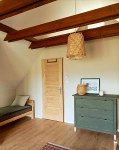 Cette chambre comprend un lit, une commode et une porte. dans l'établissement Hillside Nagymaros, à Nagymaros