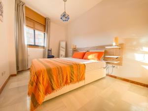 Un dormitorio con una cama grande con una manta naranja. en Casa Azul - San Luis de Sabinillas, en San Luis de Sabinillas