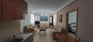 sala de estar con sofá y sillas y cocina en Family Residence en Shëngjin