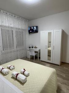 a white bedroom with a bed and a desk at Alì Babà Rooms in La Spezia