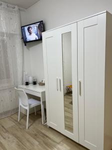 Un armario blanco en una habitación con una mesa y un televisor. en Alì Babà Rooms, en La Spezia 37 fotos más