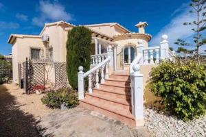 貝尼塔切利的住宿－Beautiful Villa Close to Moraira and Xabia，白色围栏和楼梯的房子