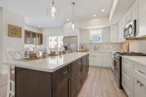 a large kitchen with white cabinets and a large island at Oasis by Seaport Stays in Wildwood