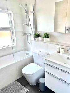 a white bathroom with a toilet and a sink at BEAUTIFUL WINDSOR COTTAGE, AMAZING LOCATION, The Castle, Ascot, Legoland, Free Parking Super Close in Windsor