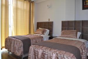 dos camas sentadas una al lado de la otra en una habitación en Departamentos Amoblados Tacna Heroica, en Tacna