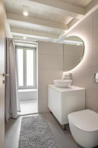 a white bathroom with a sink and a mirror at Chalki Sunrise Suites in Halki