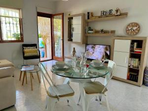 comedor con mesa de cristal y sillas en Apartamento con encanto cerca del mar, en Denia