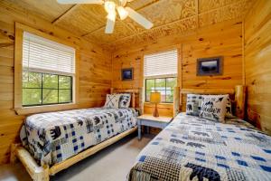a bedroom with two beds in a log cabin at Bryson City Vacation Rental - Hot Tub and Lake Views in Lauada