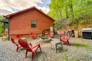a group of red chairs sitting in front of a cabin at Bryson City Vacation Rental - Hot Tub and Lake Views in Lauada