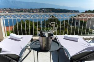 a table with two chairs and a bucket on a balcony at Apartments Siesta in Sumartin