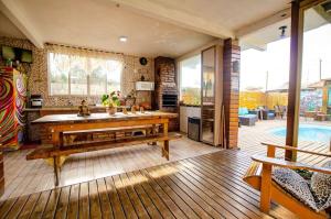 a living room with a table and a pool at Hostel Quintal do Rosa in Praia do Rosa