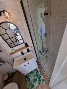 an overhead view of a bathroom with a sink and a shower at Domek nad jeziorem z jacuzzi in Sulęczyno