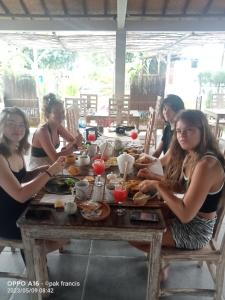 Un groupe de femmes assises à une table et mangeant de la nourriture dans l'établissement Nusa Penida Yurt, à Nusa Penida