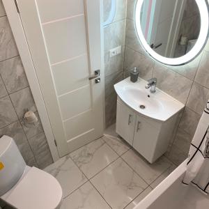uma casa de banho com um lavatório, um WC e um espelho. em Apartment in center premium em Ivano-Frankivsk