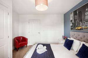 a bedroom with a bed and a red chair at Luxnightzz - Clarendon Heights - Stylish Two-Bedroom Apartment in Colchester
