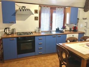 une cuisine avec des placards bleus et une table en bois dans l'établissement ETNA VIEW, à Valverde