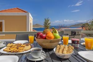 a table with a bowl of fruit and a bowl of nuts at Chalki Sunrise Suites in Halki