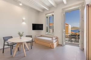 a living room with a table and a couch and a table at Chalki Sunrise Suites in Halki