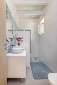 uma casa de banho branca com um lavatório e um WC em Chalki Sunrise Suites em Halki