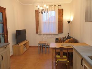 cocina y sala de estar con mesa y TV en Casita adosada, en Vigo