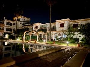 un edificio con una piscina delante de él por la noche en Apartamento con encanto cerca del mar, en Denia