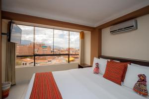 a bedroom with a bed and a large window at Principe III in Cusco