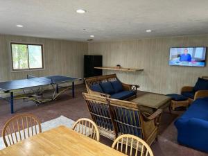 a living room with a ping pong table and a tv at North Country Retreat in Saint Ignace