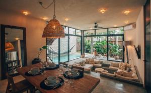 a living room with a table and a couch at Round Villa Private Pool & Jungle rooftop 2A in Tulum