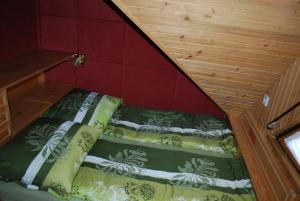 - un petit lit dans une chambre dotée d'un mur rouge dans l'établissement Apartma Mihovc, à Kamnik