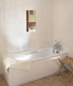 La salle de bains est pourvue d'une baignoire blanche et d'un miroir. dans l'établissement Charming Two Bedroom Cottage with Magnificent Sea Views. 10 minutes from Kenmare, à Kenmare