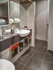 a bathroom with a sink and a vase of flowers at Oxleys 203 in Picton