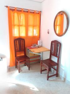 Zimmer mit einem Tisch, 2 Stühlen und einem Spiegel in der Unterkunft Giuli Room in San Salvador de Jujuy