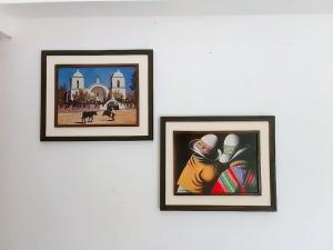 tres cuadros enmarcados en una pared blanca en Giuli Room en San Salvador de Jujuy