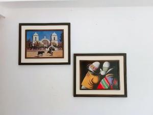 three framed pictures on a white wall at Giuli Room in San Salvador de Jujuy