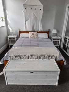 a bedroom with a large white bed with two tables at Oxleys 203 in Picton