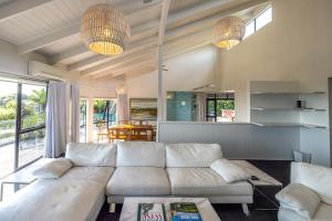 a living room with a white couch and two lights at Villa Valmont - Stay Waiheke in Palm Beach