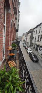 balkon z ławkami i samochodami zaparkowanymi na ulicy w obiekcie Aux frais de la princesse - Gîte citadin 3 épis w mieście Chimay