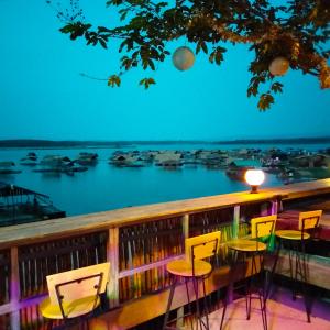 d'une table et de chaises sur un balcon avec vue sur l'eau. dans l'établissement บ้านสวนริมน้ำวังใหญ่2 วังสามหมอ อุดรธานี, 