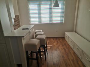 a room with a bar with chairs and a window at ZOJA City Centre Apartments in Kavadarci