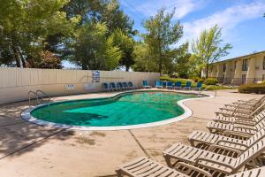 a swimming pool with lounge chairs next to a building at Heritage Inn Express Roseville in Roseville