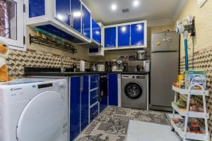 cocina con armarios azules, lavadora y secadora en Dar Qaysar, en Chefchaouen
