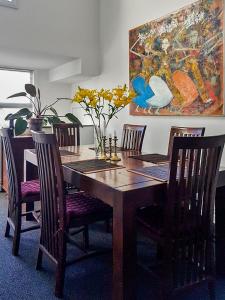 a dining room table with chairs and a painting on the wall at Oxleys 203 in Picton
