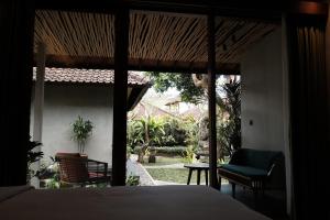 a bedroom with a bed and a view of a garden at Cloudspace Ubud in Ubud